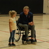 Hunter Pinke gives some instruction to GMR kindergartener Olivia Lambert before racing her in the GMR School gym during his visit on May 18. Pinke, a native of Wishek, N.D., talked about his journey from a Division I University of North Dakota football player to a chest-down paraplegic at the age of 22 following a skiing accident in Colorado on December 27, 2019. Pinke spoke to the public and GMR seventh to twelfth grade students first and then spoke to the kindergarten through sixth grade students, playing a couple games with the latter group. His talk with the younger group was titled, “Dream, Set, Go.” (photo by Ryan Bergeron)