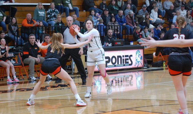 Teagan Landsrud holds the ball while looking for a teammate to pass to during the first half of the Gators’ 48-42 road win over the Warren-Alvarado-Oslo Ponies in Warren on February 23. Landsrud posted eight points and 14 rebounds in the win. (photo by Ryan Bergeron)