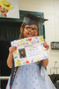 Badger kindergarten graduate Zara Schmidt smiles while holding up her diploma during the school’s kindergarten graduation ceremony on May 12. (photo by Macy Majer)