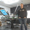 Alex Truscinski stands in front of the screen printing equipment he works with at Studio10, his apparel printing business located just to the south of River’s Edge near the Highway 11 and Highway 32 intersection in Greenbush. A racer, Truscinski’s number has always been 10, so, when naming the business, he wanted to choose something that had to do with him. (photo by Ryan Bergeron)